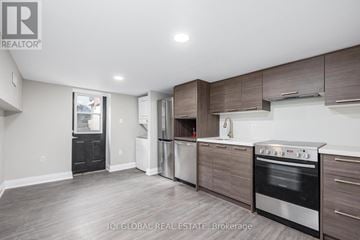 Toronto (Trinity-Bellwoods) apartment for rent - A modern kitchen with dark wood cabinets and stainless steel appliances.