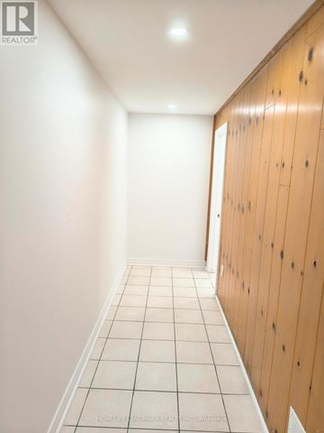 Toronto (Don Valley Village) apartment for rent - A long hallway with white tile floors and wood paneling on the walls.