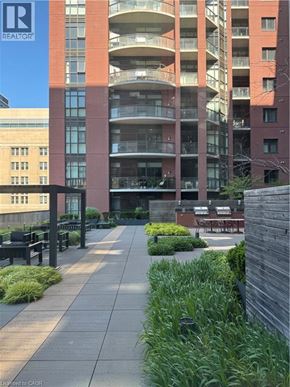 Hamilton condo for rent - A large building with a balcony on the second floor.