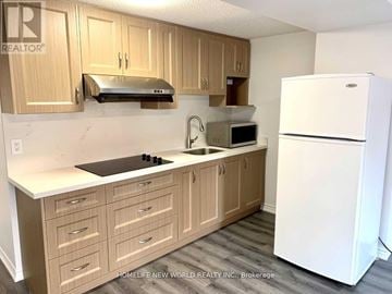 Markham (Victoria Square) apartment for rent - A kitchen with wooden cabinets and a white refrigerator.