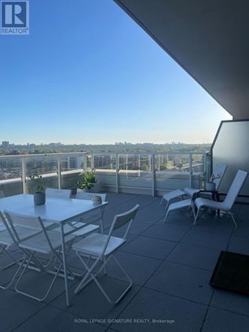 Toronto (Banbury-Don Mills) condo for rent - A balcony with a table and chairs overlooking a cityscape.