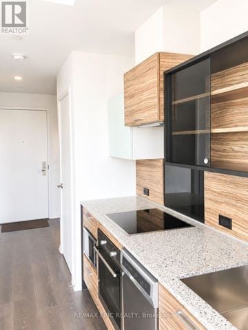 Toronto (Bay Street Corridor) townhouse for rent - A modern kitchen with a stainless steel sink and wooden cabinets.