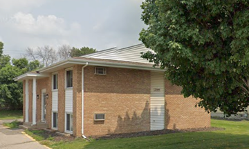 North Saint Paul apartment for rent - A small brick house with a white garage door.