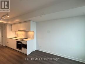 Toronto (Bay Street Corridor) condo for rent - A modern kitchen with white cabinets and a wooden floor.