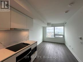 Toronto (Bay Street Corridor) condo for rent - A kitchen with a stove top oven and a window with a view of a city.