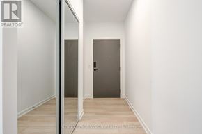 Markham (Greensborough) condo for rent - A hallway with a door on the right and a mirror on the left.