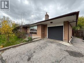Toronto (Kingsview Village-The Westway) apartment for rent - A house with a grey garage door and a brown roof.