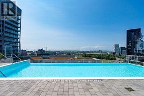 Toronto (South Riverdale) condo for rent - A swimming pool on a rooftop with a cityscape in the background.