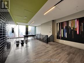 Toronto (South Riverdale) condo for rent - A modern office space with a wooden floor and a large abstract painting on the wall.