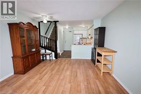 Kitchener townhouse for rent - A wooden floor in a room with a cabinet, a table, and a staircase.