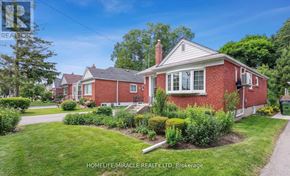 Toronto (Wexford-Maryvale) apartment for rent - A red brick house with a white window and a chimney is surrounded by greenery.