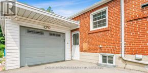 Toronto (Wexford-Maryvale) apartment for rent - A garage door with a window above it and a brick wall to the right.