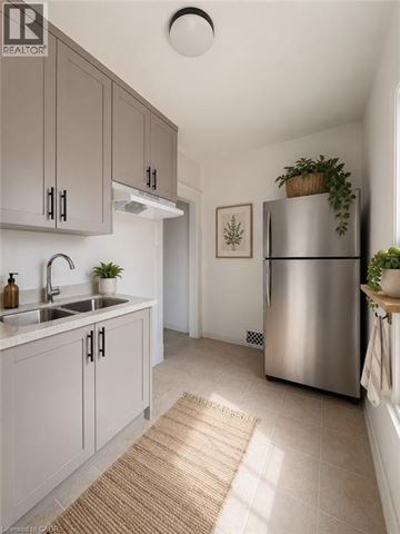 Hamilton apartment for rent - A modern kitchen with a stainless steel refrigerator and grey cabinets.