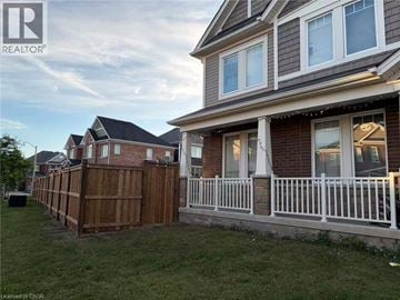 Cambridge apartment for rent - A house with a white fence and a brown wooden fence in front.