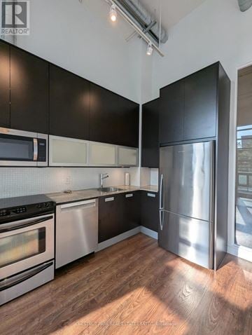 Toronto (Casa Loma) condo for rent - A modern kitchen with black cabinets and stainless steel appliances.