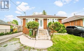Toronto (Wexford-Maryvale) apartment for rent - A house with a brick facade and a green trash can in front.