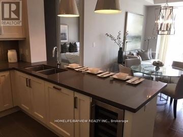 Markham (Angus Glen) condo for rent - A kitchen with a sink and a counter with a table and chairs.