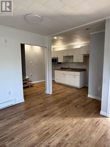 Kawartha Lakes (Bobcaygeon) multi-family for rent - A realtor photo of a kitchen and living room with wood floors.