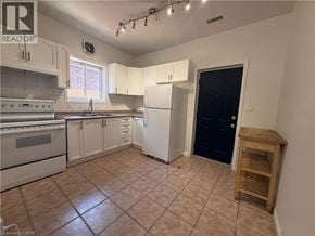 Hamilton apartment for rent - A kitchen with white cabinets and a black door.