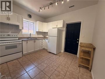 Hamilton apartment for rent - A kitchen with white cabinets and a black door.