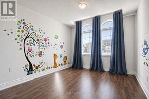 Newmarket (Woodland Hill) apartment for rent - A room with a tree mural on the wall and a window with curtains.