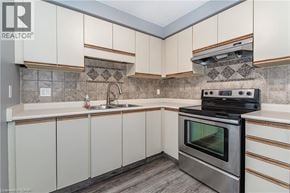 Waterloo condo for rent - A modern kitchen with a stove top oven and a sink.