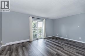 Waterloo condo for rent - A room with a sliding glass door and wooden flooring.