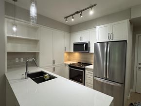 Langley apartment for rent - A modern kitchen with stainless steel appliances and white countertops.