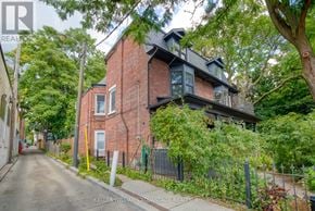 Toronto (Cabbagetown-South St. James Town) apartment for rent - A red brick house with a black fence in front of it.