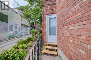 Toronto (Cabbagetown-South St. James Town) apartment for rent - A white door is on the side of a red brick building.