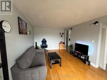Oshawa (Donevan) apartment for rent - A living room with a grey couch and a black coffee table.