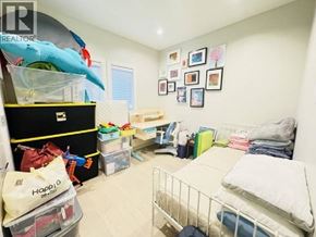 Vancouver apartment for rent - A child's bedroom with a bed, toy storage, and a wall of pictures.