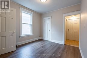 Hamilton (Stipley) multi-family for rent - A room with a white door, a window, and a wooden floor.