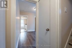 Hamilton (Stipley) multi-family for rent - A hallway with a door on the right and a staircase on the left.