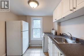 Hamilton (Stipley) multi-family for rent - A small kitchen with white appliances and cabinets.