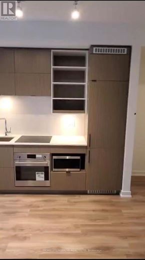 Toronto (Bay Street Corridor) condo for rent - A modern kitchen with a stainless steel oven and a wooden floor.