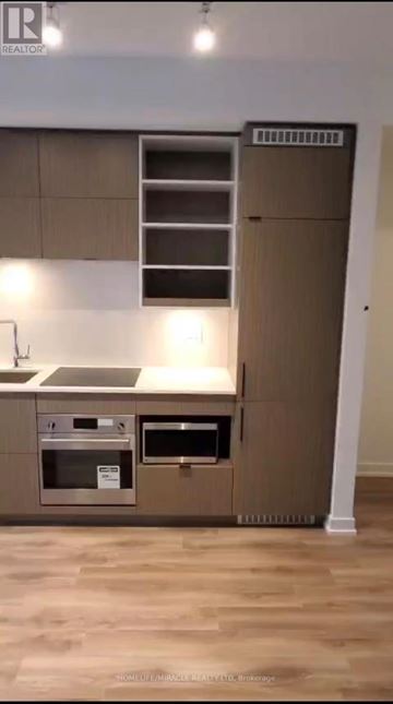 Toronto (Bay Street Corridor) condo for rent - A modern kitchen with a stainless steel oven and a wooden floor.