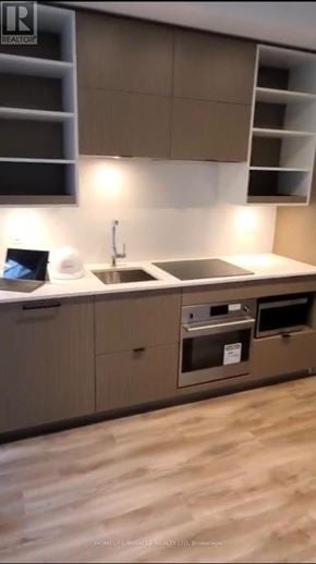 Toronto (Bay Street Corridor) condo for rent - A modern kitchen with a sink, stove, and cabinets.