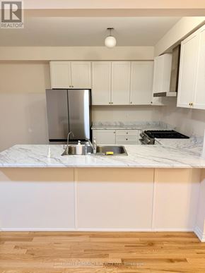 Oshawa (Kedron) apartment for rent - A kitchen with white cabinets and a marble countertop.