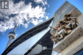 Toronto (Waterfront Communities) condo for rent - A sculpture of a group of people is in the foreground with the CN Tower in the background.