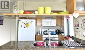 Toronto (Waterfront Communities) condo for rent - A kitchen with a refrigerator, sink, and stove.