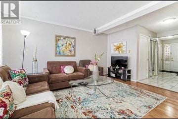 Brampton (Bramalea West Industrial) townhouse for rent - A living room with a brown couch, a rug, and a painting on the wall.