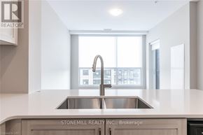 Kitchener condo for rent - A modern kitchen with a sink and a window.