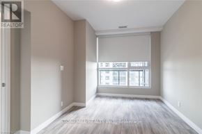 Kitchener condo for rent - A room with a view of a cityscape through the window.
