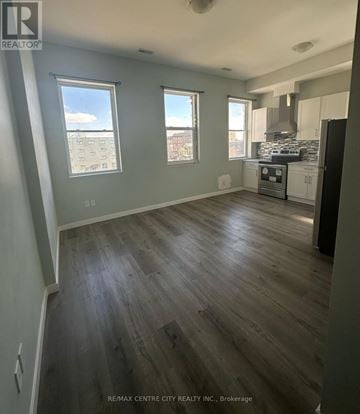 London East (East K) multi-family for rent - A kitchen with a stove top oven and a refrigerator.