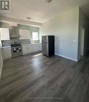 London East (East K) multi-family for rent - A kitchen with a black fridge and wooden floors.