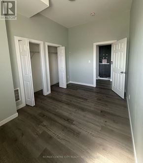 London East (East K) multi-family for rent - A room with wood flooring and white doors.