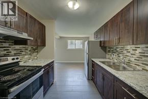 Waterloo apartment for rent - A kitchen with dark wood cabinets and a black stove top oven.