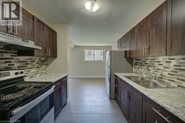 Waterloo apartment for rent - A kitchen with dark wood cabinets and a black stove top oven.
