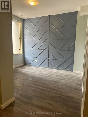 London East (East K) multi-family for rent - A room with a grey wall and wooden flooring.